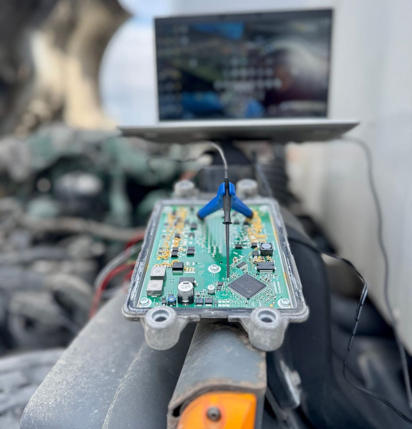ECU on the bench with a probe connected and a laptop reading it